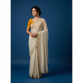 Shafusion beige star georgette saree with intricate gold embellishments and a mustard yellow unstitched blouse