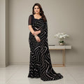 Shafusion black georgette saree with white abstract print and unstitched blouse worn by a model in a studio setting