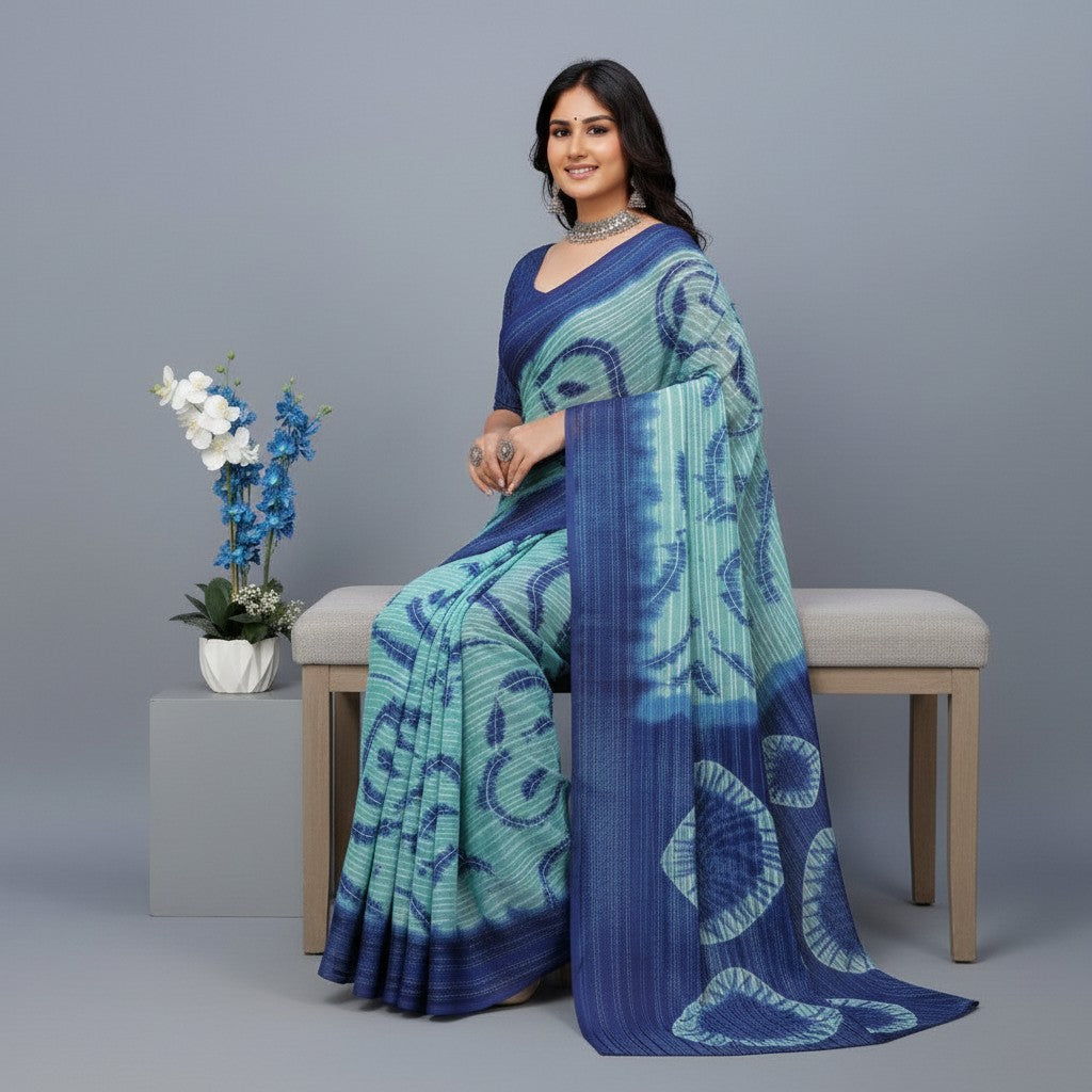 Shafusion blue georgette printed saree with unstitched blouse worn by a woman sitting on a bench