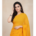 Shafusion gold georgette plain saree worn by a woman with traditional jewelry for festive and casual occasions