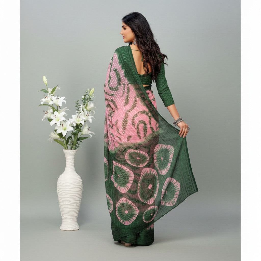 Shafusion green and pink printed georgette saree worn by a woman with an unstitched blouse, standing near a vase.