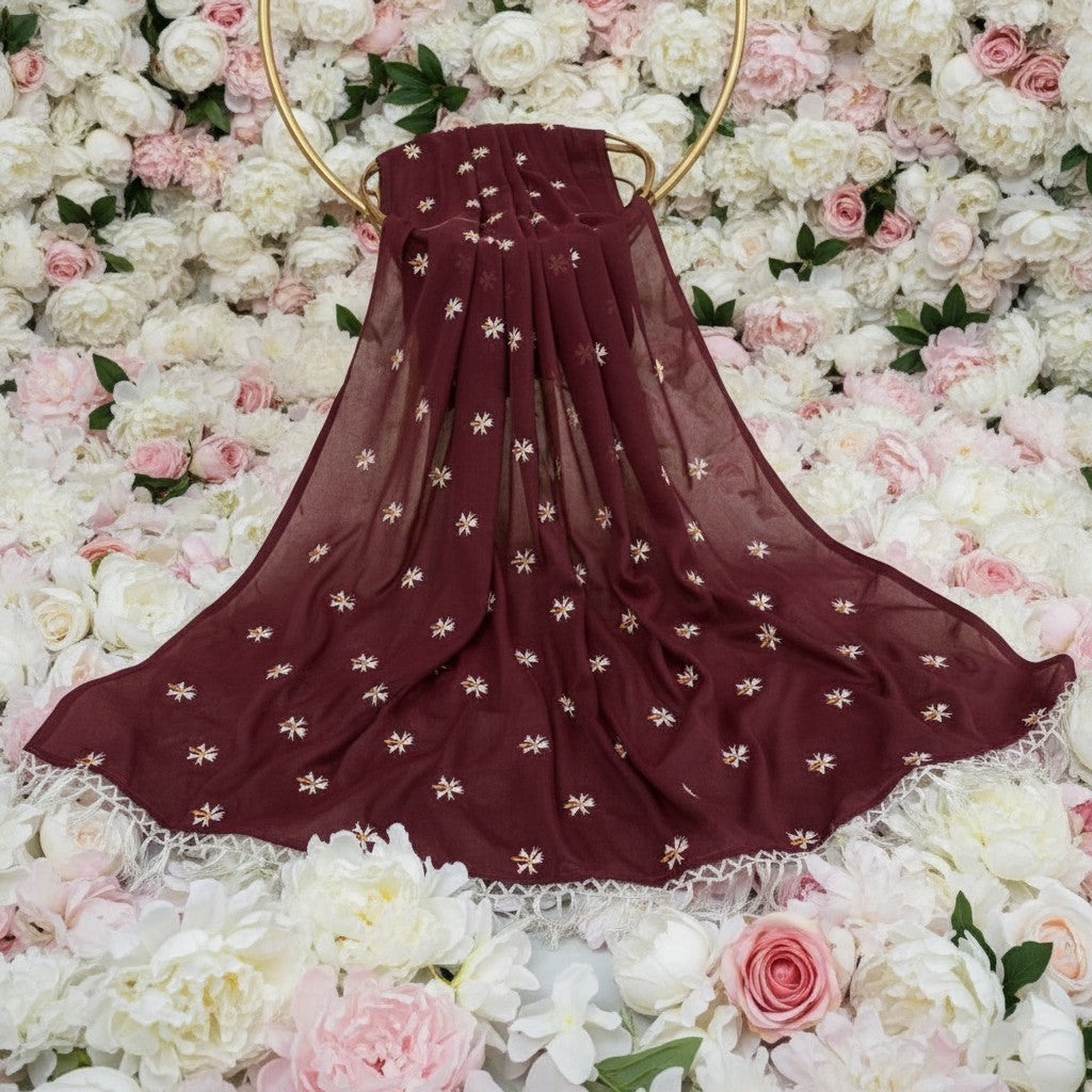 Shafusion maroon georgette saree with delicate floral embroidery and white fringe border against a floral backdrop