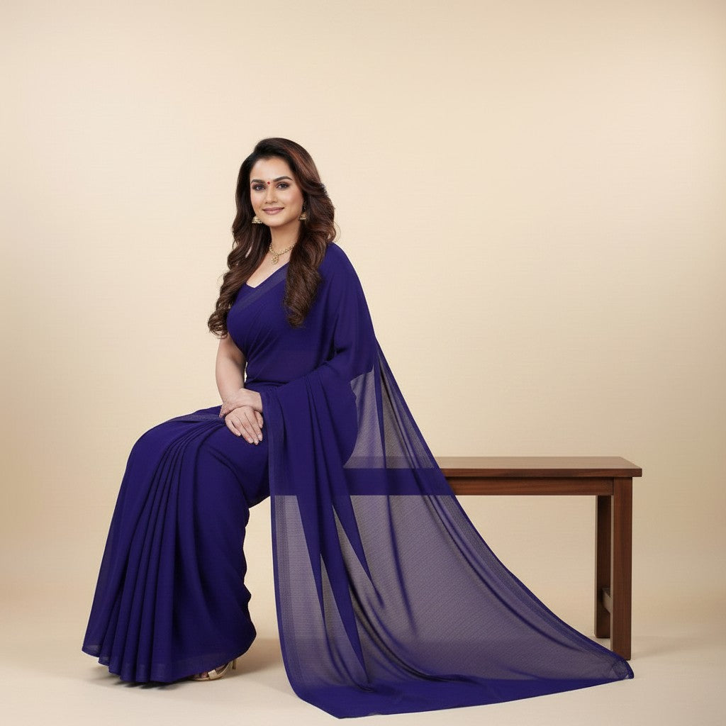 Shafusion navy blue georgette plain saree worn by a woman sitting on a wooden bench, elegant festive attire