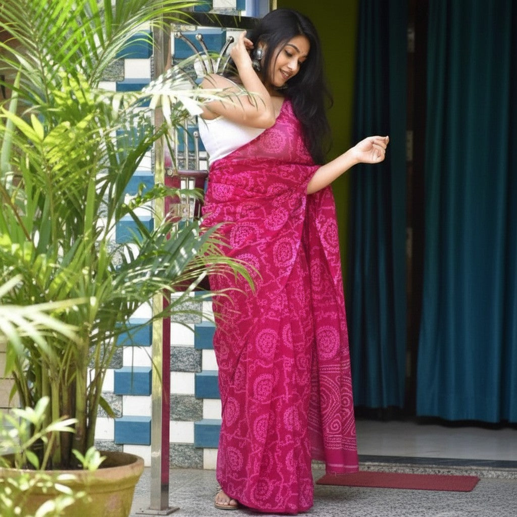 Shafusion pink georgette printed saree with unstitched blouse worn by a woman standing near a potted plant