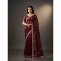 Shafusion red georgette saree featuring intricate gold embroidery and an unstitched blouse worn by a model