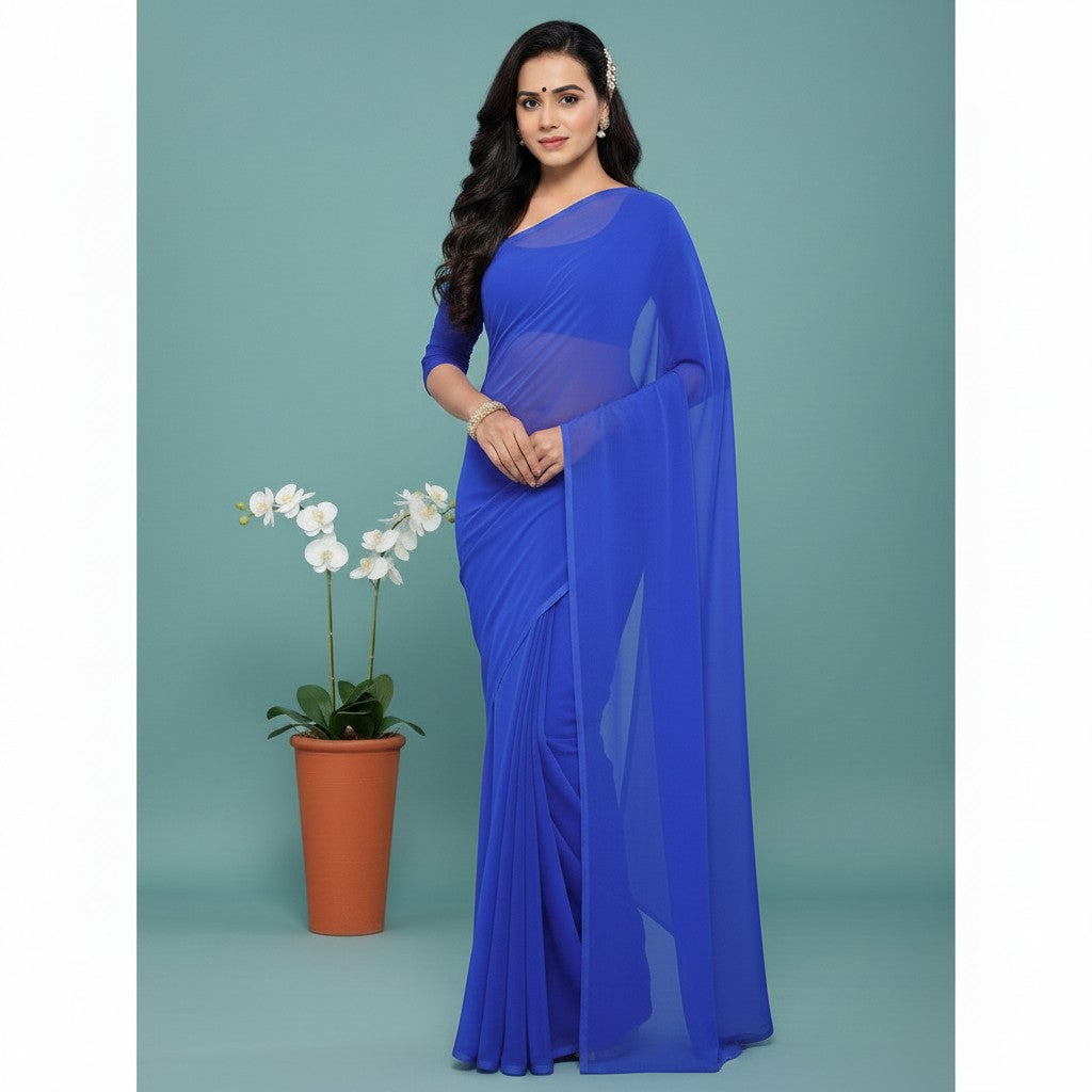 Shafusion royal blue georgette plain saree with matching blouse worn by a model standing next to a potted orchid.